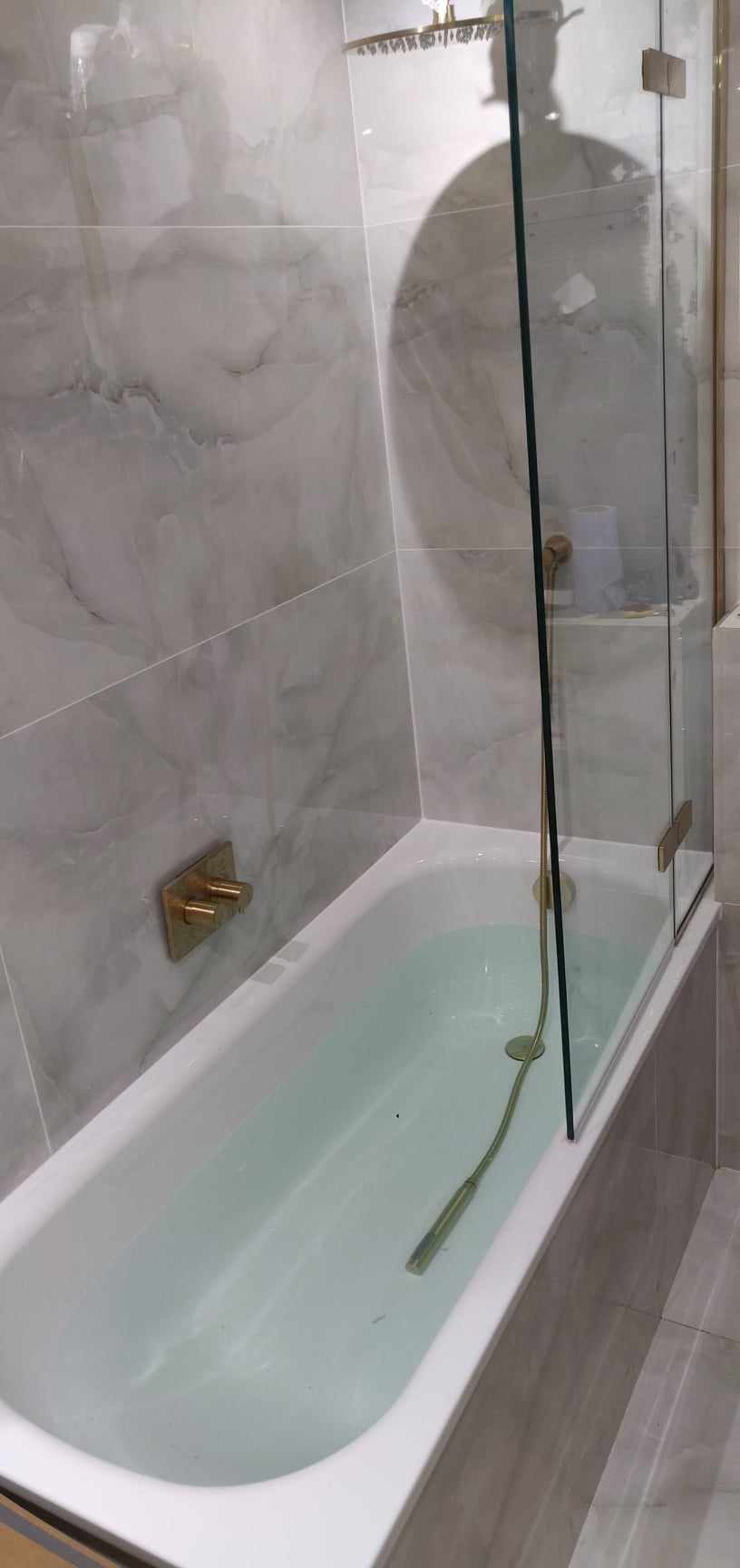 Finished marble-effect bathroom with bath and shower screen